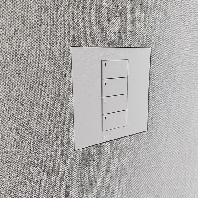White Lutron Keypad flush mounted onto fabric wall.