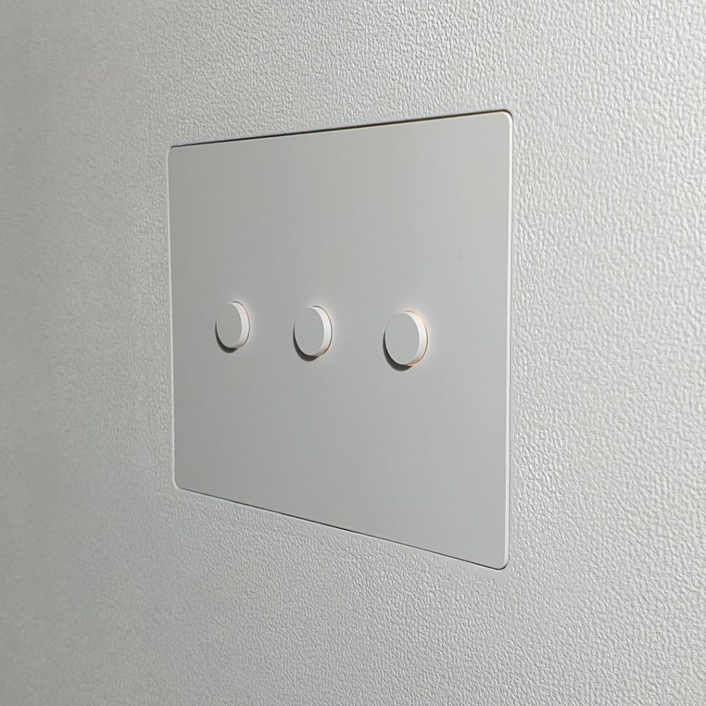 White Alisse Lutron Keypad flush mounted onto plastered wall.