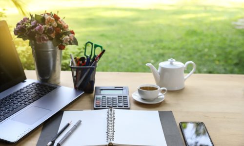 Wood table office outdoor with note book ,pen, smartphone,comput A calm and peaceful outdoor working office environment.